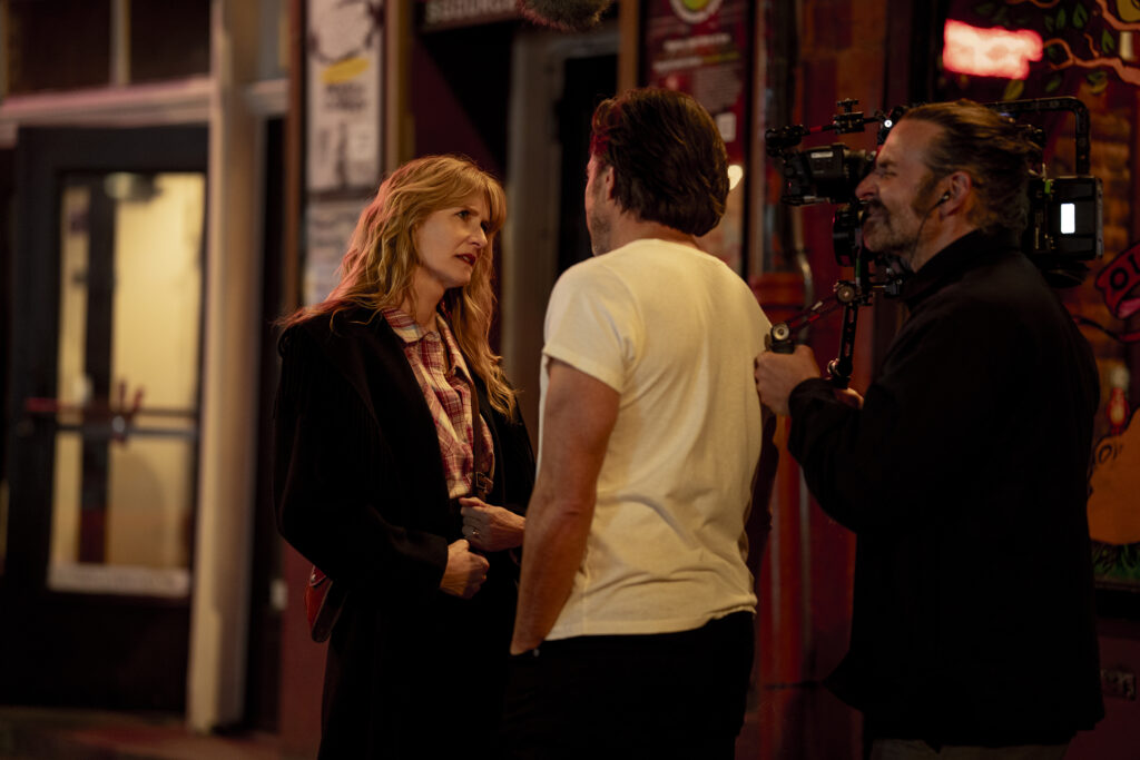 Laura Dern e Will Arnett com o diretor Bradley Cooper no set de 'Isto Ainda Está de Pé?' 